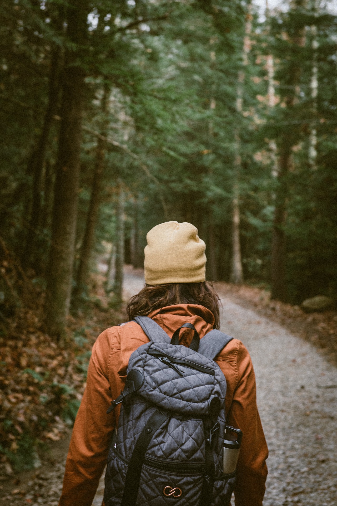 Person rucking on a forest trail with a loaded backpack